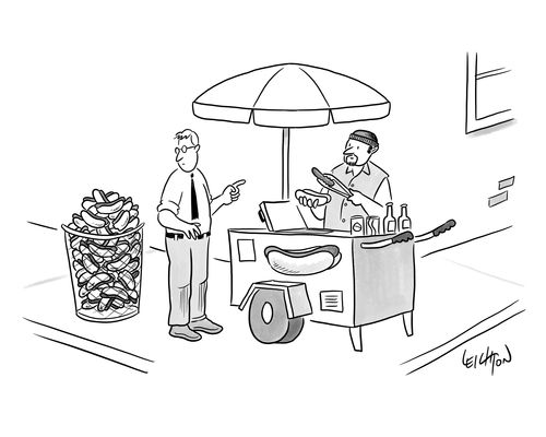 A businessman is buying a hot dog from a cart for his lunch.