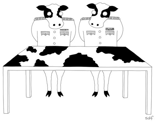 Two cows in military dress looking at a map table with a cow-design.