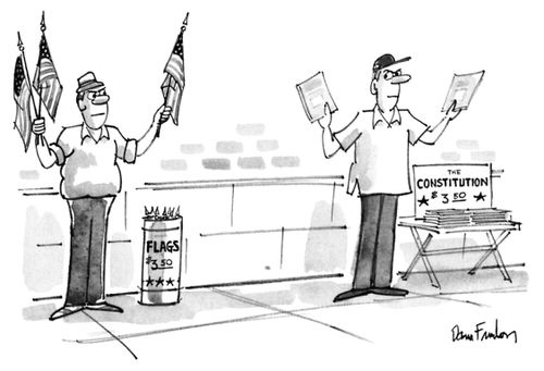 A man peddles U.S. flags on the sidewalk, next to a man peddling copies of the U.S. constitution