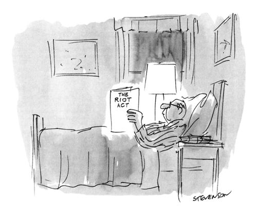A man reading a book entitled "The Riot Act" in bed.