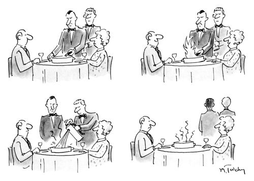 A waiter flambes a meal.