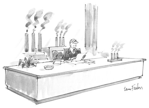 A businessman sits with an executive toy of smokestacks.