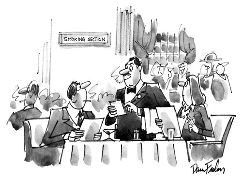 A couple sitting in the smoking section of a restaurant is approached by a waiter who is smoking a cigarette