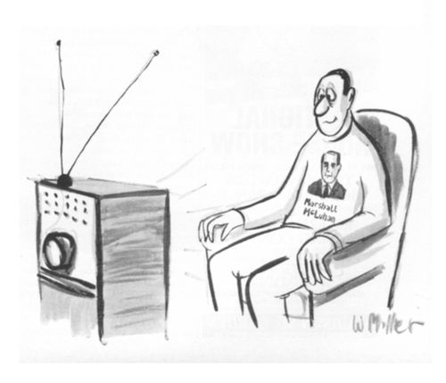 A man watches TV while wearing a Marshall McLuhan sweatshirt.