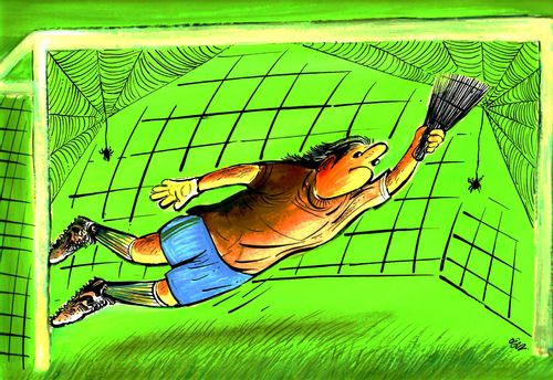 Goalkeeper with a brush leaps around his goalnet which is covered in cobwebs and spiders.