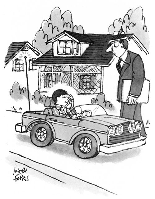 Boy in toy car talking on phone.