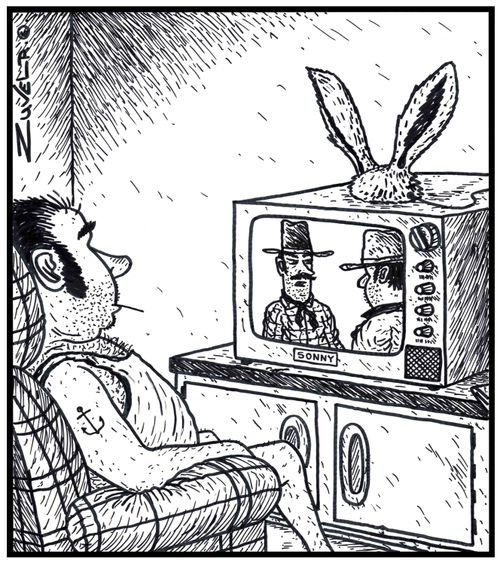 Rabbit ears on top of a man's TV acting as an antenna.
