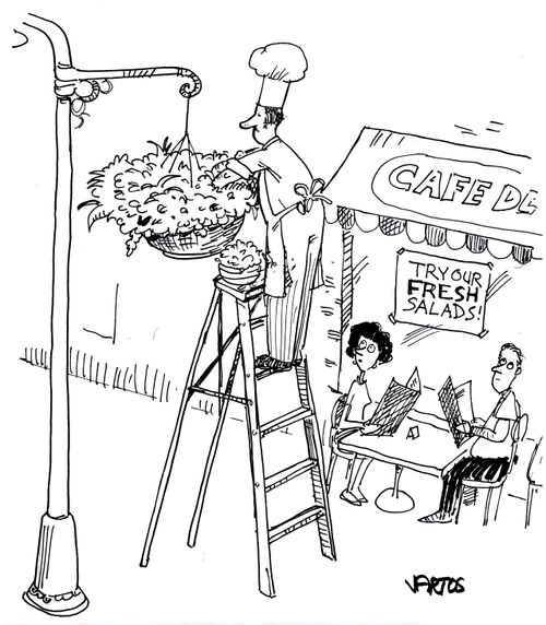 Chef picking salad leaves from a hanging basket outside his restaurant.