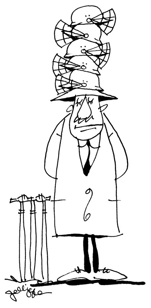 Cricket umpire with pile of helmets.