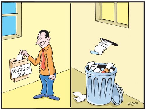 Man putting a piece of paper into a Suggestion Box. The piece of paper is seen flying out of a hole on the other side of the wall into a bin.