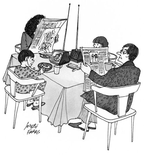 Family all doing different things around the breakfast table.