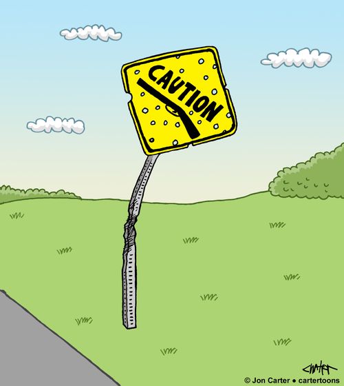 Caution sign for firearms is shot up with holes in it.