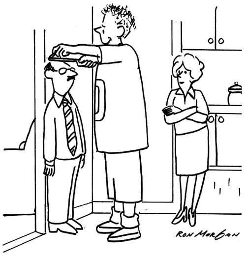 Son measuring his father against the wall.