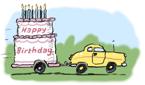 Giant birthday cake on a trailer being towed by a car