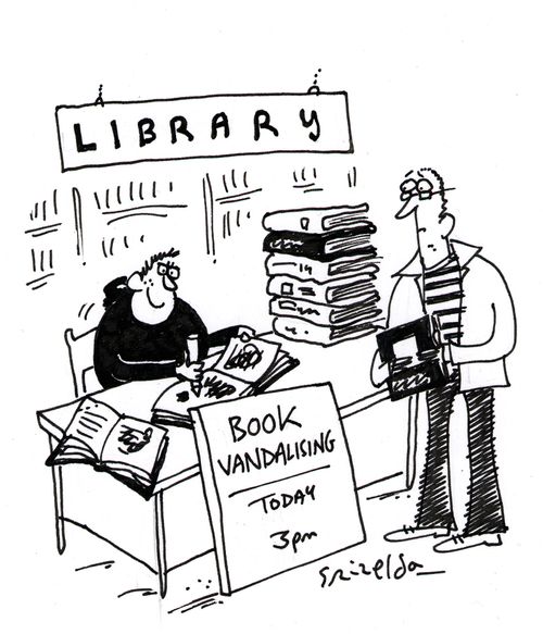 Library: Teenager sat at a desk with sign that reads 'Book Vandalising - today 3pm'