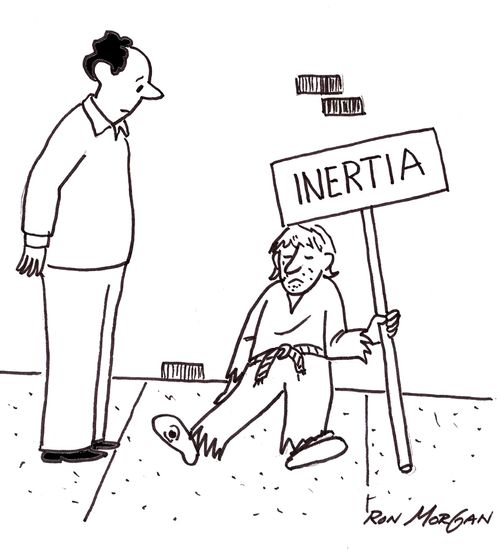 Beggar lying on street hold sign reading: INERTIA.