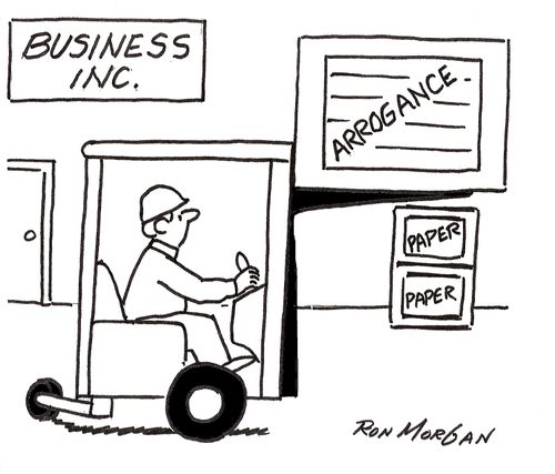 Fork lift carries huge box labelled 'Arrogance' in company warehouse.