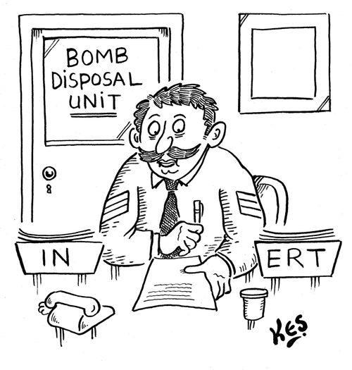 Bomb disposal officer sits at desk near workboxes: IN/ ERT.