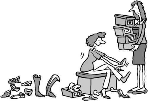 Shop assistant watches a woman trying many shoes in shoe shop.
