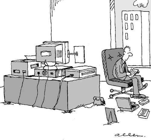 Man in office, desk covered in computer equipment, uses floor for photos, desk pads etc.