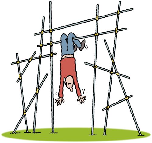 A man swinging upside down by his legs on a scaffolding frame.