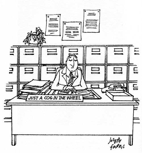 Desk sign reads: 'Just a cog in the wheel.'