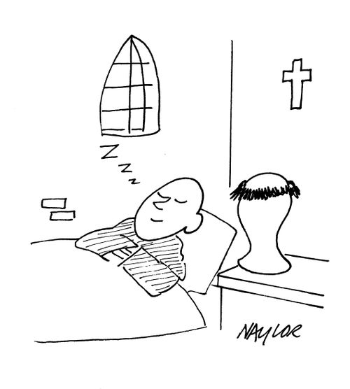 Monk sleeping with wig on wigstand.
