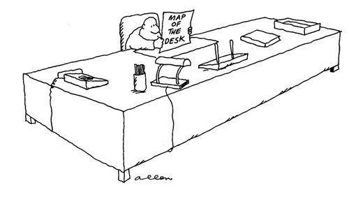 Man at huge desk with a map entitled, 'Map of the Desk'.
