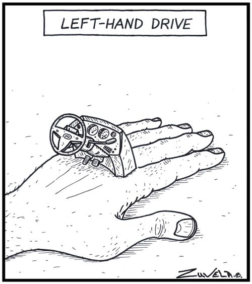 Left-hand drive - A left hand with a car steering wheel and console on it.