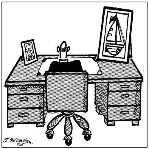 An executive with photo of both his wife and his sailboat on desk.
