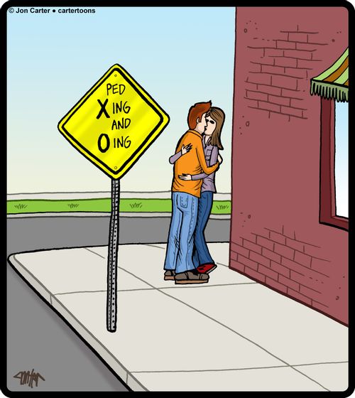 Couple kissing by a 'Ped Xing and Oing' sign.