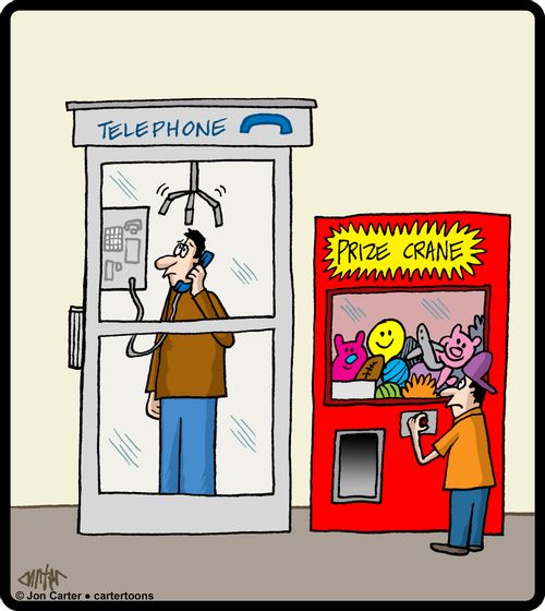 Crane arm is lowering to pick up man in the telephone box next to arcade game.