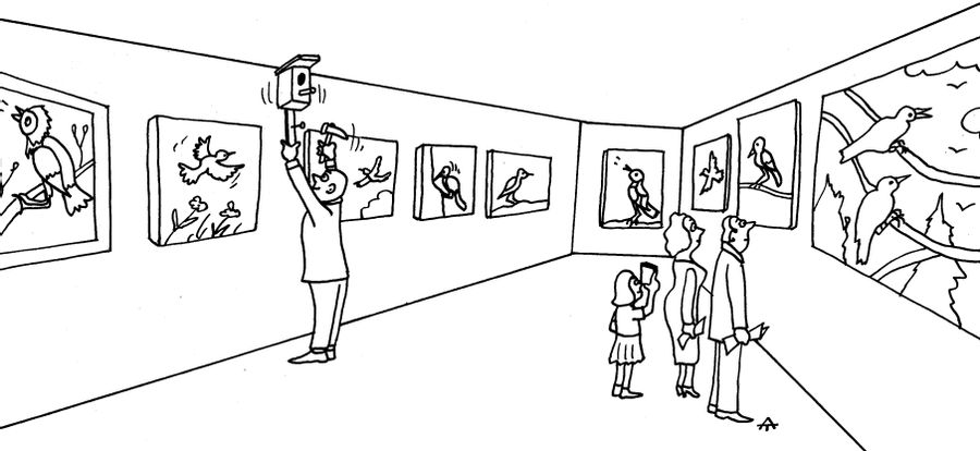 Man puts up a birdhouse in a gallery full of wildlife pictures.
