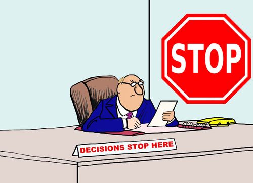 Business cartoon of businessman in his office, a stop sign and nameplate that reads 'decisions stop here'.