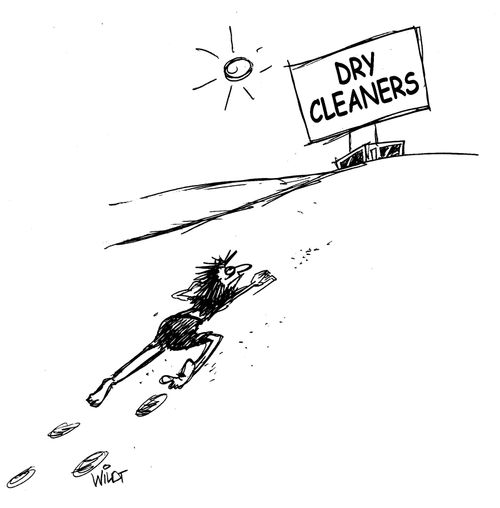 Man crawling on desert see a dry cleaners in distance. 