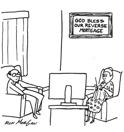 Elderly couple sits in living room with wall sign that states: God Bless our Reverse Mortgage.