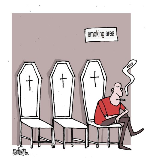 A man sits on coffin-shaped chairs in the smoking area.