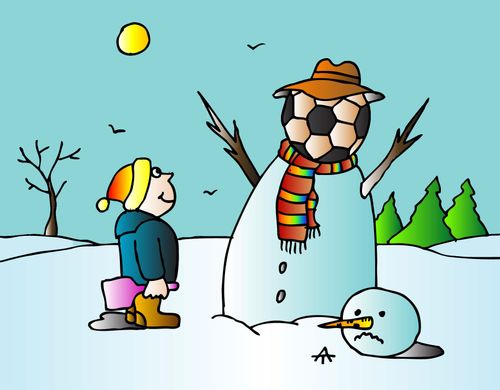 A boy builds a snowman with a football for a head.