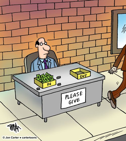 A man sits at a desk on the sidewalk with a beggar sign on his desk, collecting money in his desk tray.