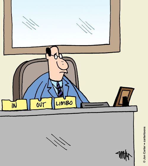 An office worker sits at his desk with desk trays labeled, 'IN,' 'OUT,' and 'LIMBO.'