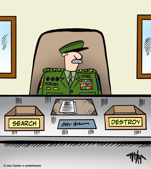 A military officer sits at his desk with desk trays marked 'Search' and 'Destroy.'