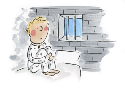 Prisoner sadly sits looking out his barred window.
