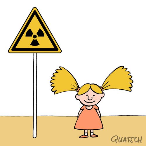 A little girl with bunches standing next to a radioactive materials sign